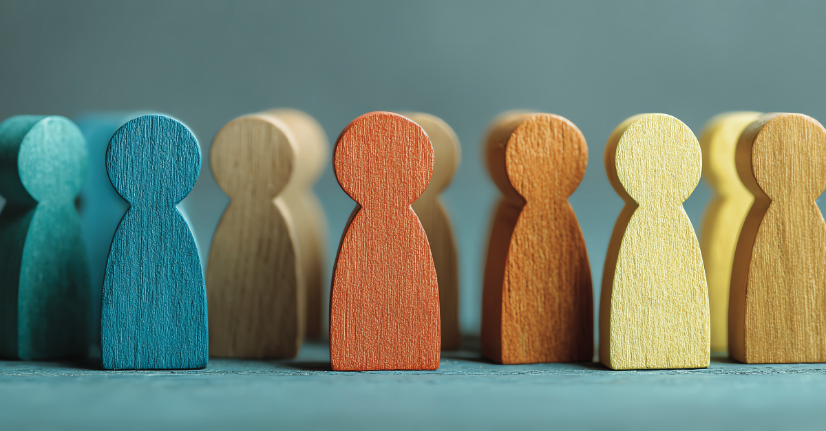 Colorful wooden figures in a row; one blue, one red, others various warm colors.