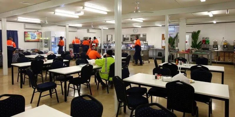 A Group Of People Are Sitting At Tables In A Large Room — Leichhardt Accommodation in Mornington, QLD