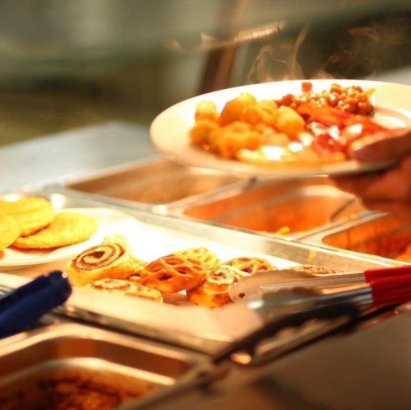 Buffet: Plate of Food Being Held Over Food Containers with Tongs — Leichhardt Accommodation in Mornington, QLD
