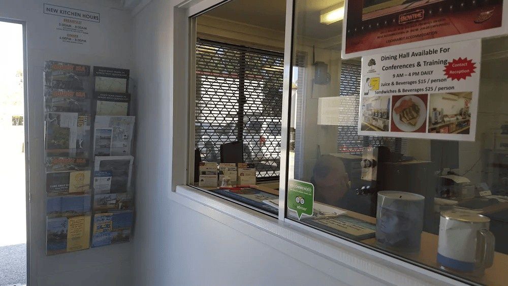 A Shop Window with A Menu Sign and Brochures on The Wall Next to It — Leichhardt Accommodation in Mornington, QLD