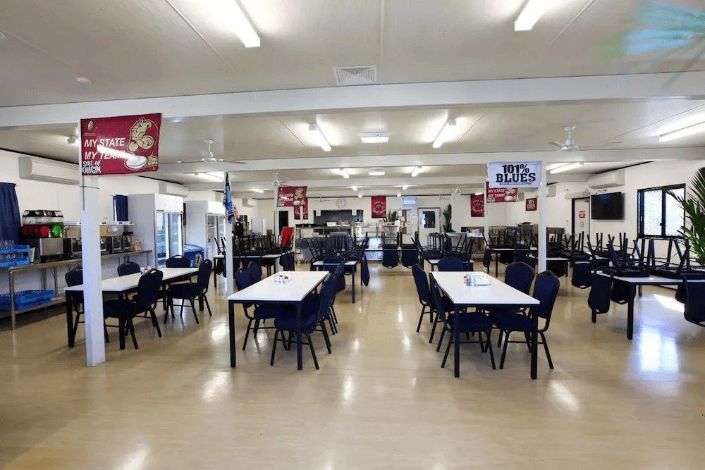 Empty Dining Hall with White Tables and Blue Chairs — Leichhardt Accommodation in Mornington, QLD