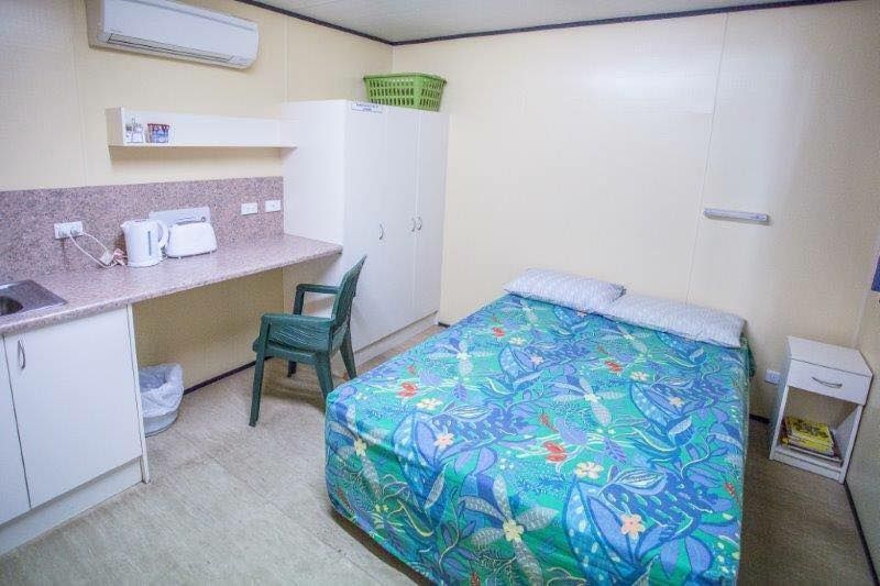 A Bedroom With A Single Bed And A Desk — Leichhardt Accommodation in Mornington, QLD