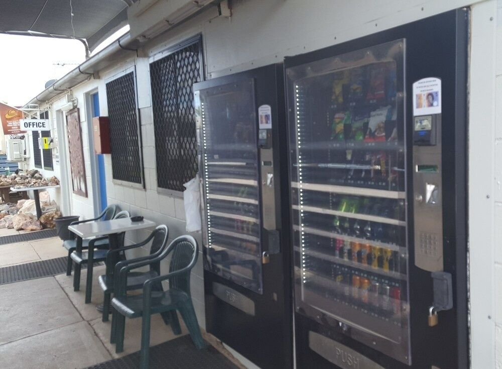 Outdoor Vending Machines Beside a Building; Small Table, Chairs — Leichhardt Accommodation in Mornington, QLD