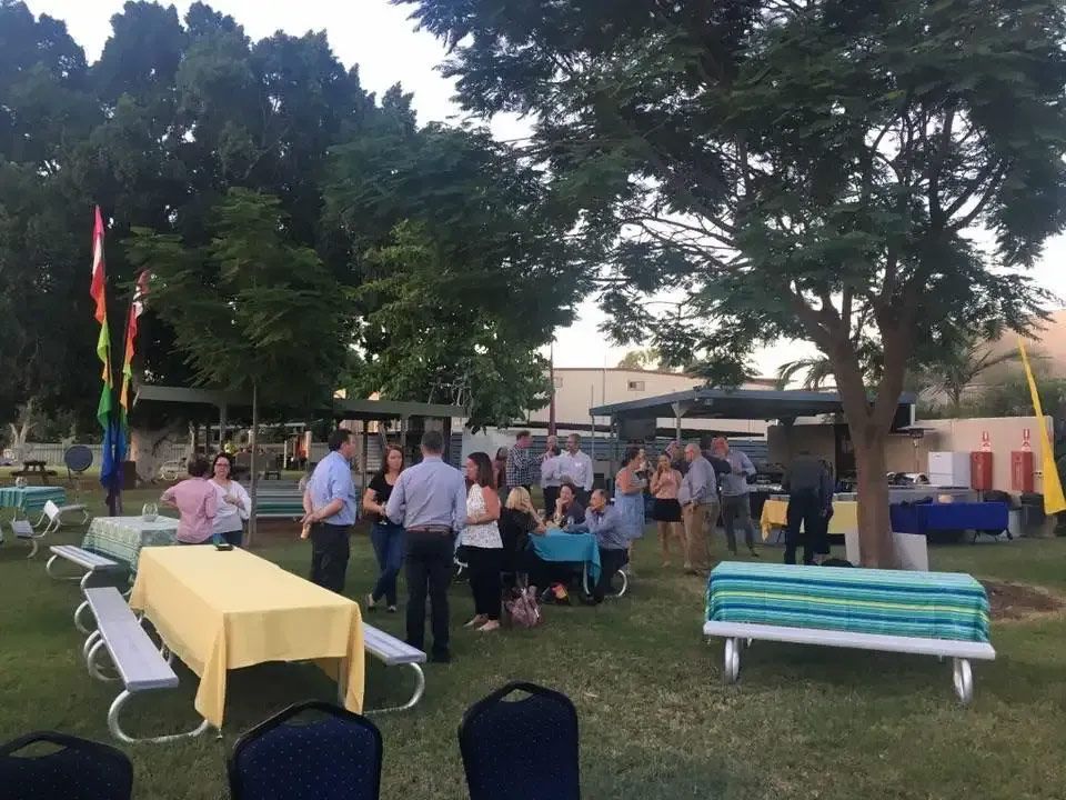 A Group Of People Standing Around Tables And Benches In A Park — Leichhardt Accommodation in Mornington, QLD