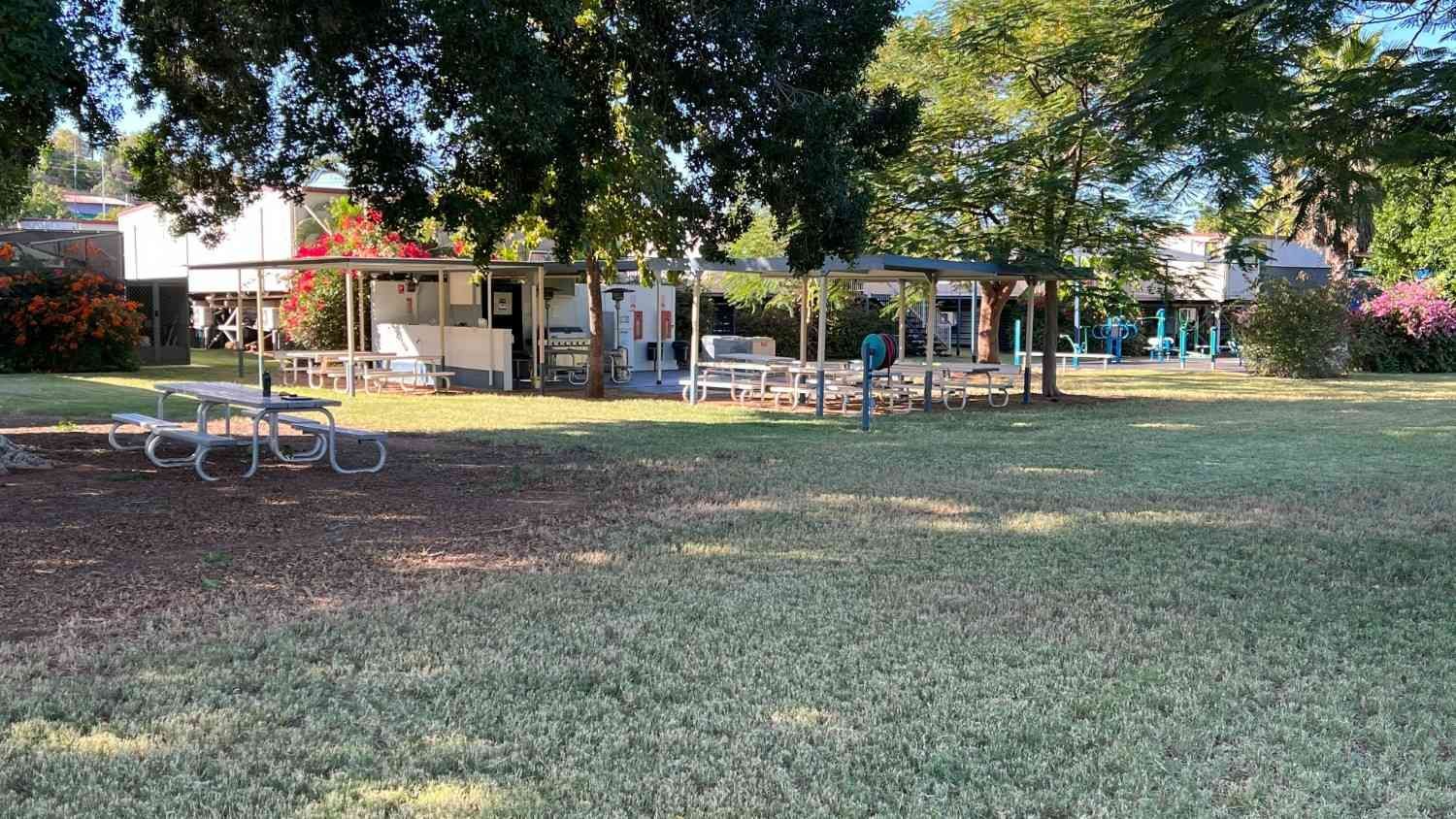 A Grassy Park with Picnic Tables, Trees, and A Covered Concession Area — Leichhardt Accommodation in Mornington, QLD
