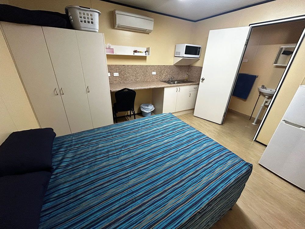 A Bedroom With A Bed, Cabinets, And A Sink — Leichhardt Accommodation in Mornington, QLD