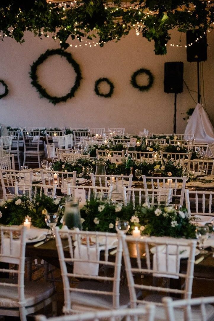 A room filled with tables and chairs decorated for a wedding reception.