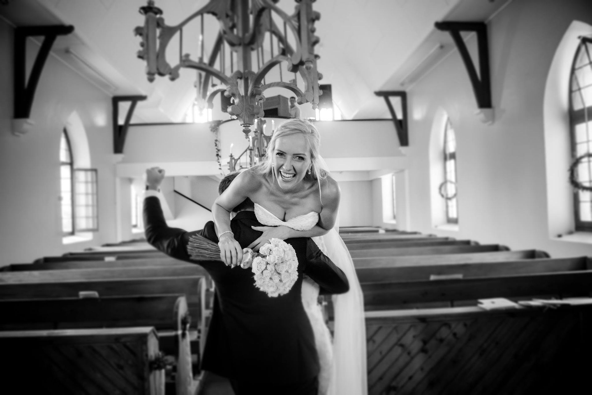 A black and white photo of a bride and groom in a church