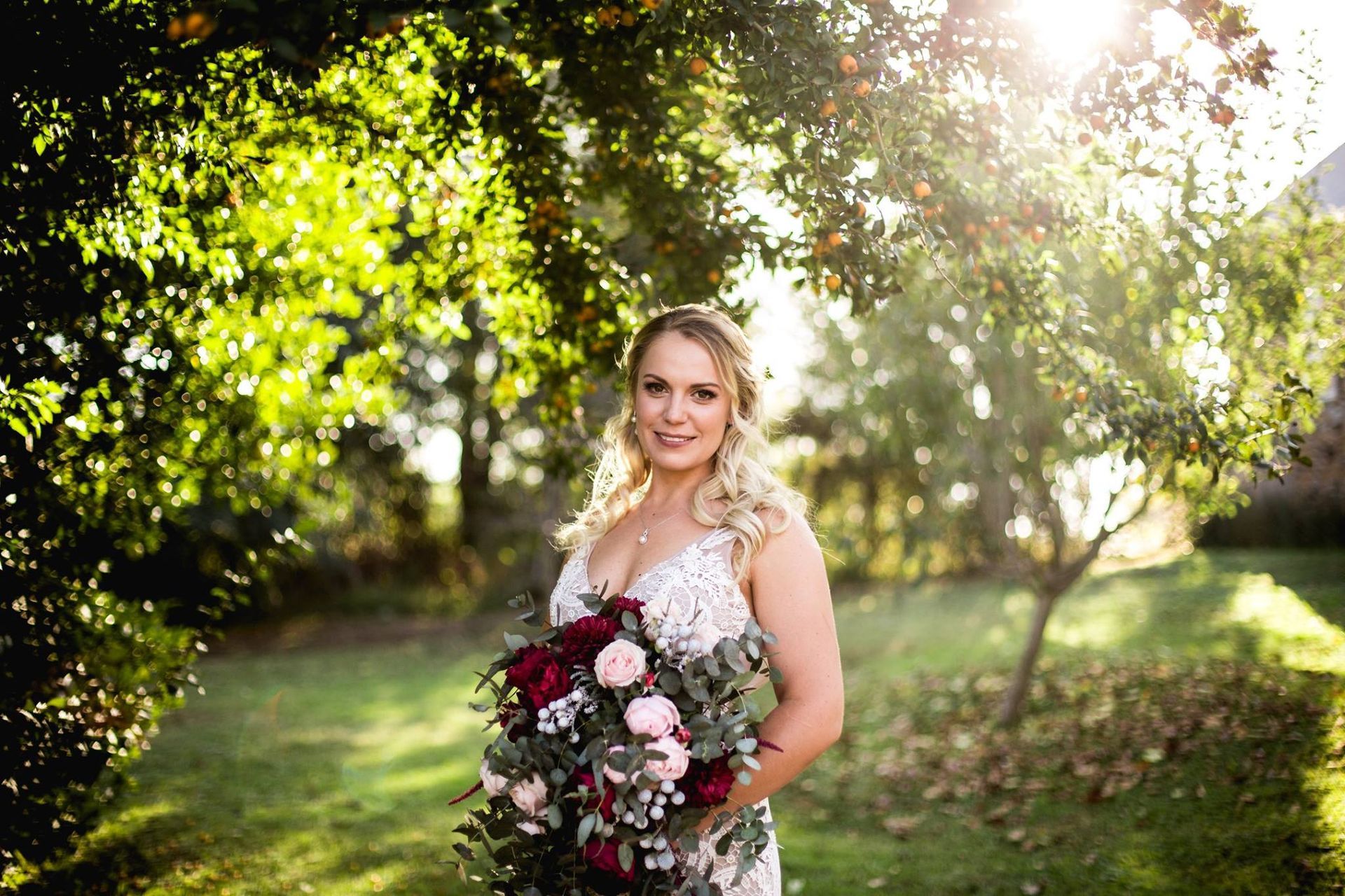 A bride in a wedding dress is holding a bouquet of flowers.