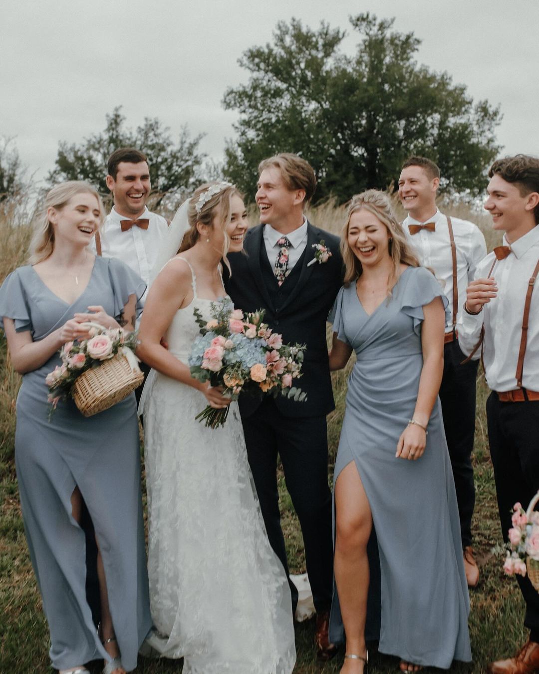 A bride and groom are posing for a picture with their wedding party