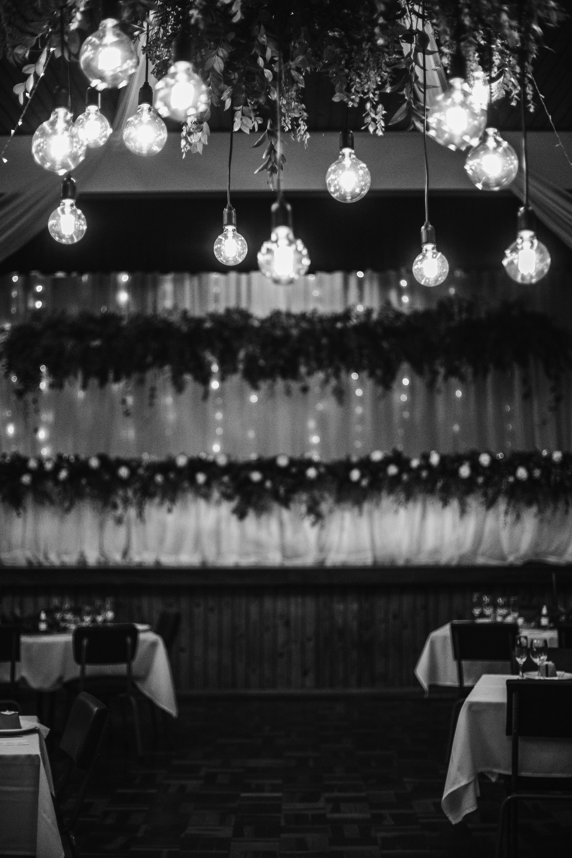 A black and white photo of a restaurant with tables and chairs