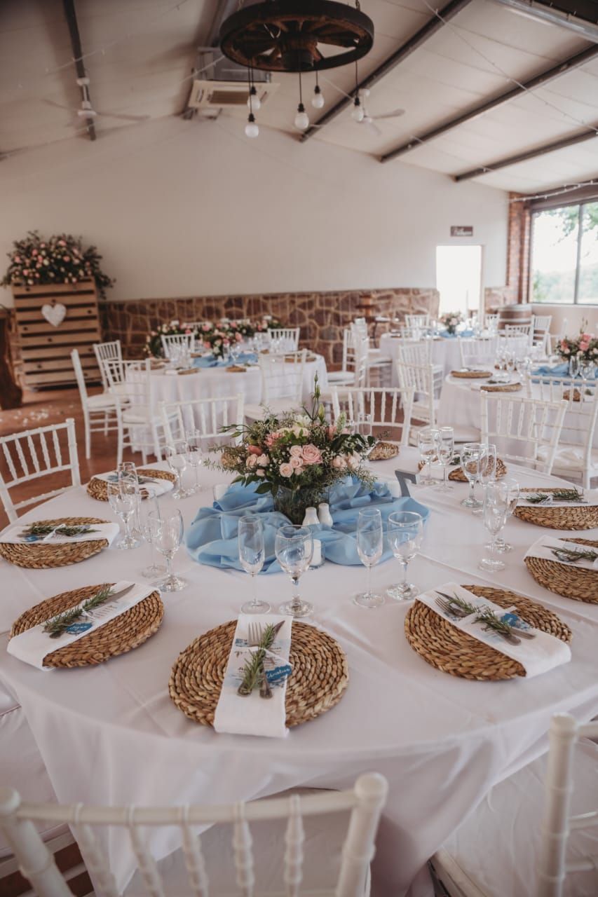 A large room with tables and chairs set up for a wedding reception.