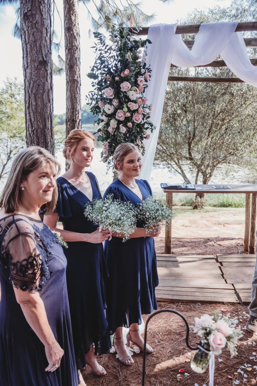 A group of women standing next to each other holding bouquets of flowers.