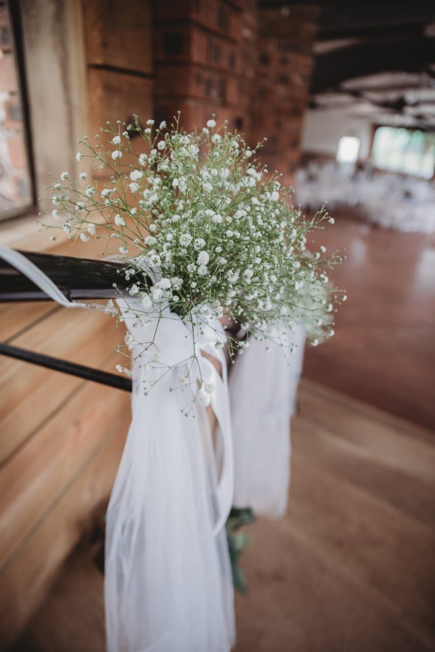A couple of flowers hanging from a railing in a room.