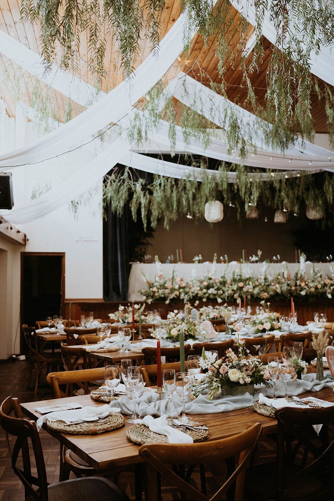A large room with tables and chairs set up for a wedding reception.