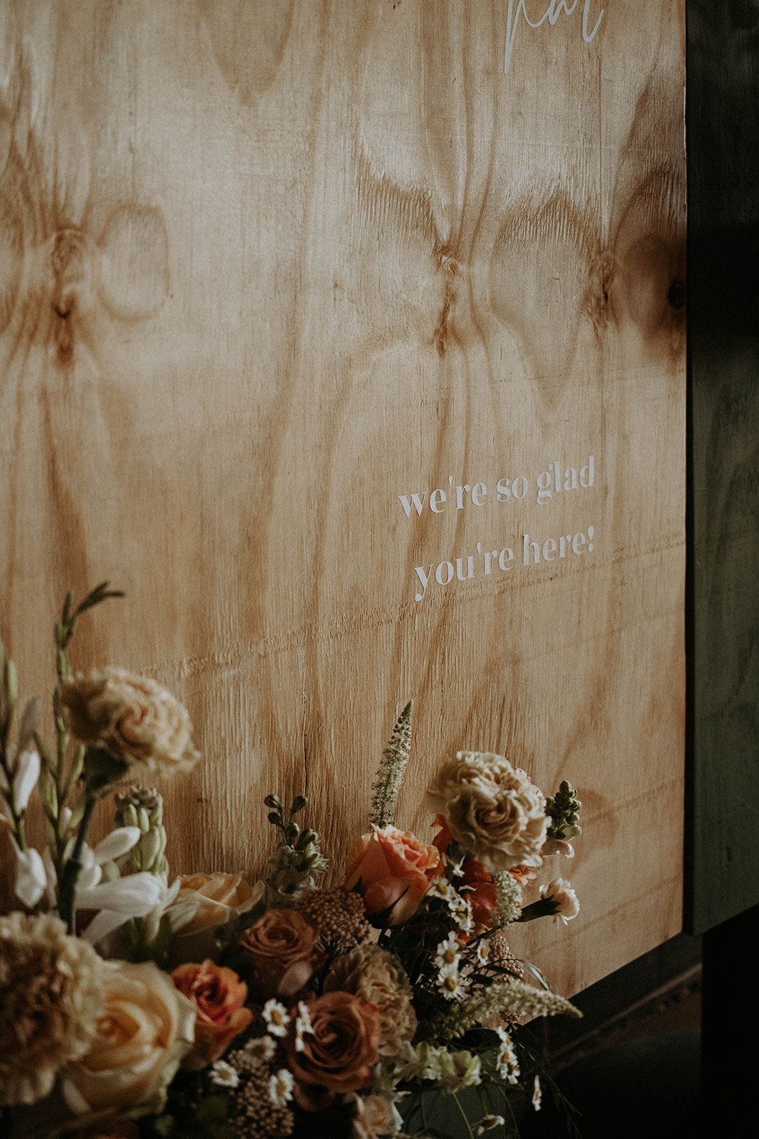 A bouquet of flowers is sitting in front of a wooden wall.