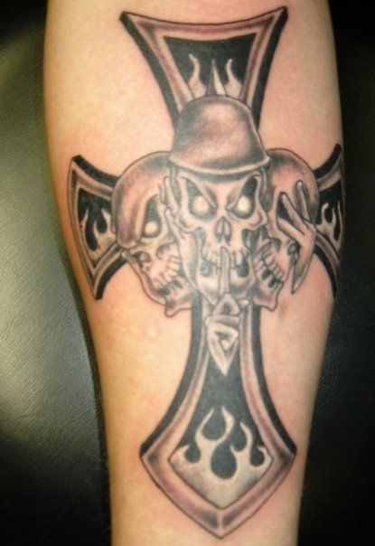 A tattoo of a cross with three skulls on it
