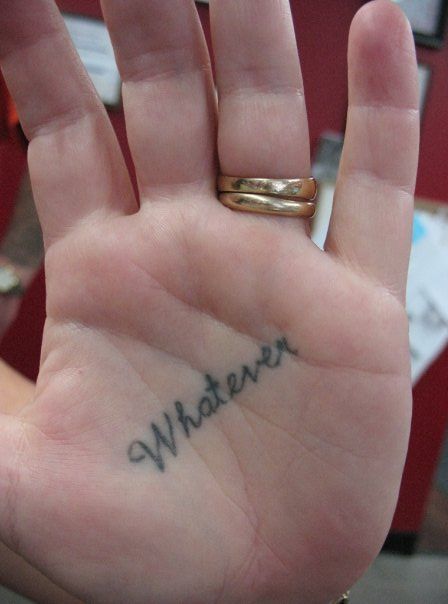 A hand with a tattoo that says whatever on it
