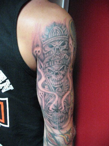 A man has a tattoo of a skull with a crown on his arm