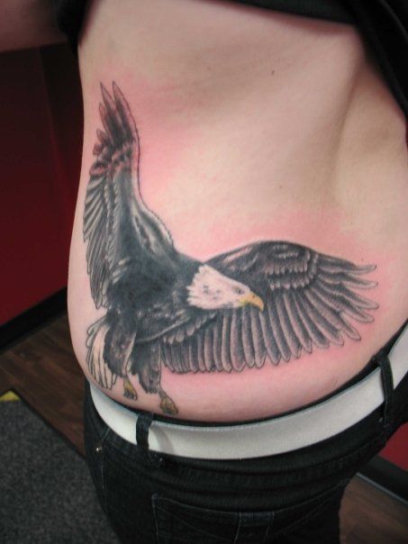 A person has a tattoo of an eagle on their back