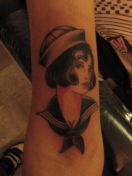 A woman has a tattoo of a sailor on her arm