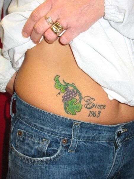 A woman has a tattoo on her lower back that says since no 3