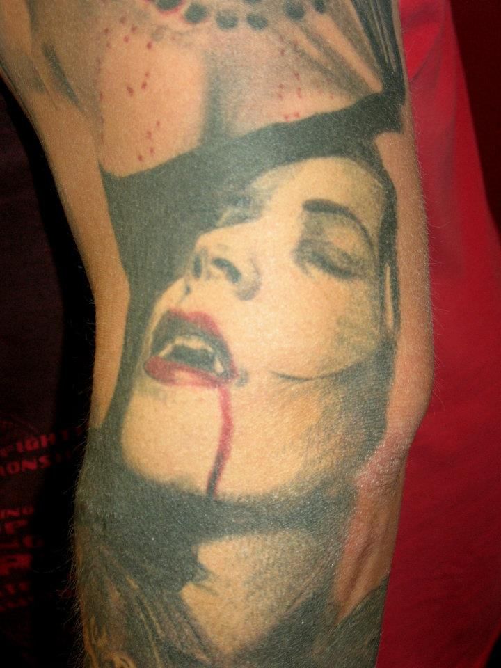 A man has a tattoo of a vampire on his arm.