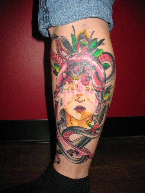 A person has a tattoo of a woman 's face on their leg