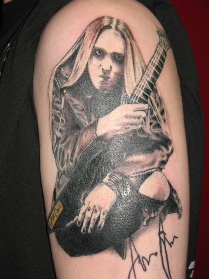 A man has a tattoo of a woman holding a guitar
