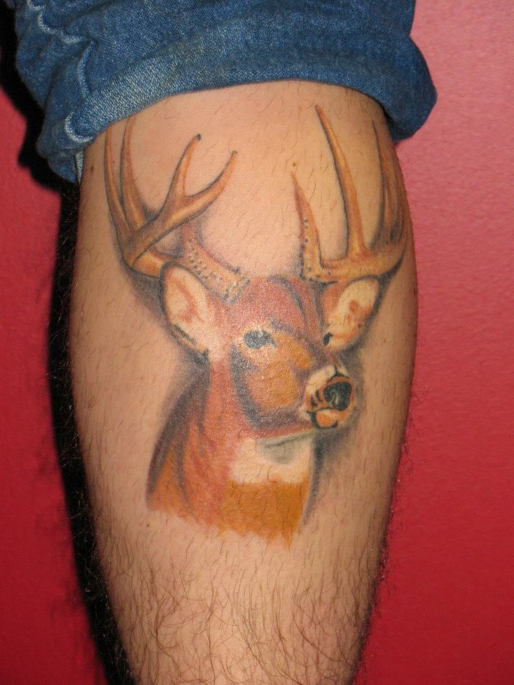 A man has a tattoo of a deer on his leg
