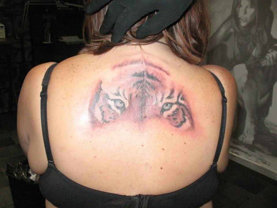 A woman has a tattoo of two tigers on her back