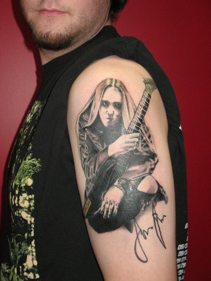 A man has a tattoo of a woman playing a guitar