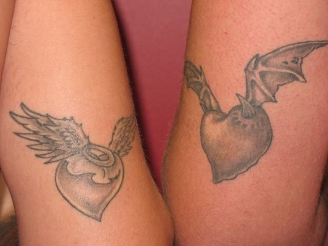 A woman has a tattoo of a heart with wings on her arm