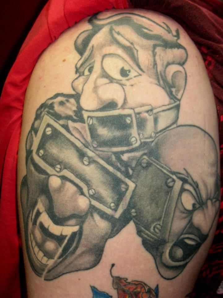 A person has a tattoo of a cartoon character on their shoulder