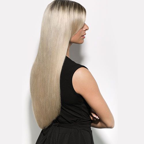 Eine Frau mit langen blonden Haaren trägt ein schwarzes Kleid.
