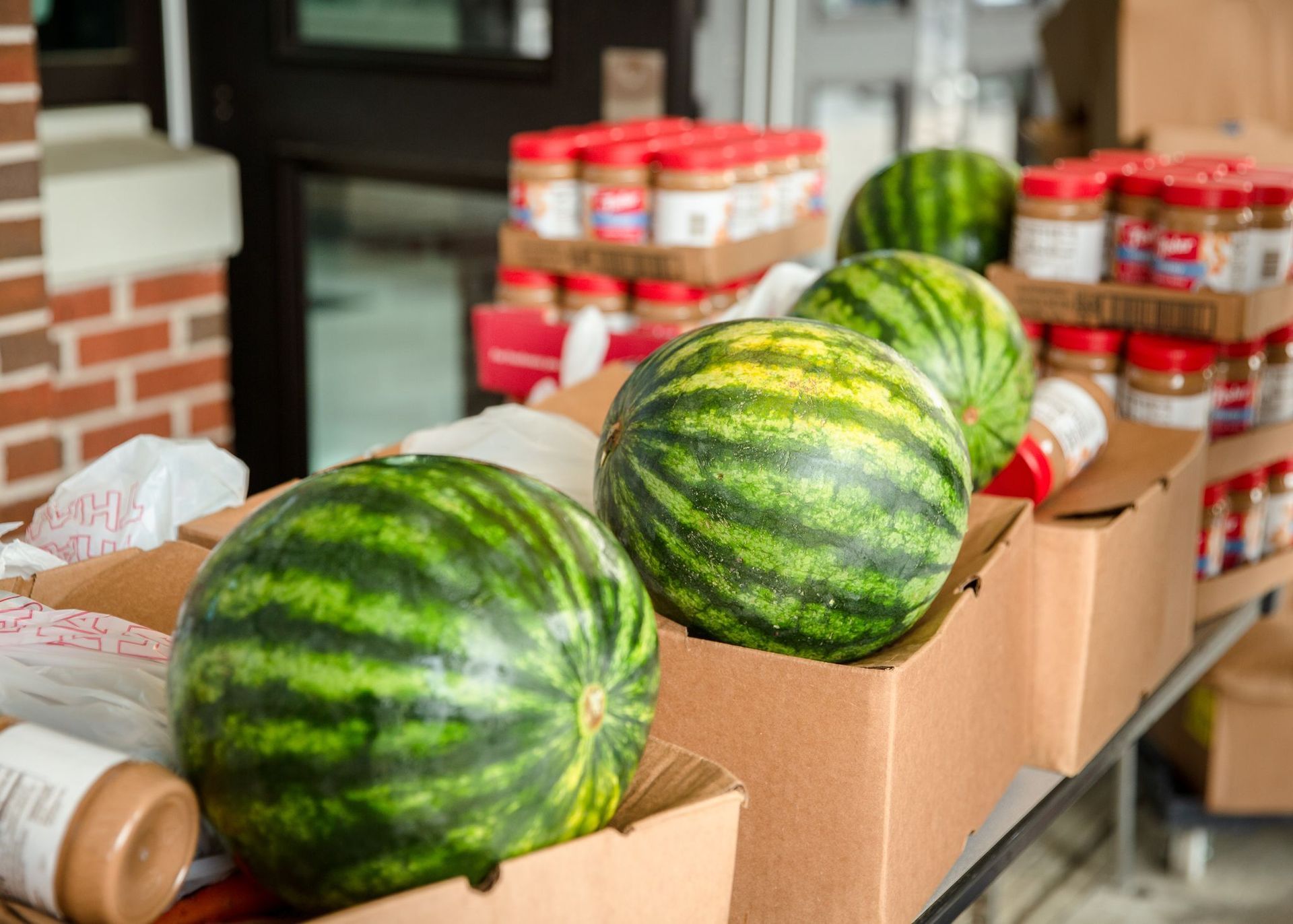 Watermelons are sitting in cardboard boxes on a table.