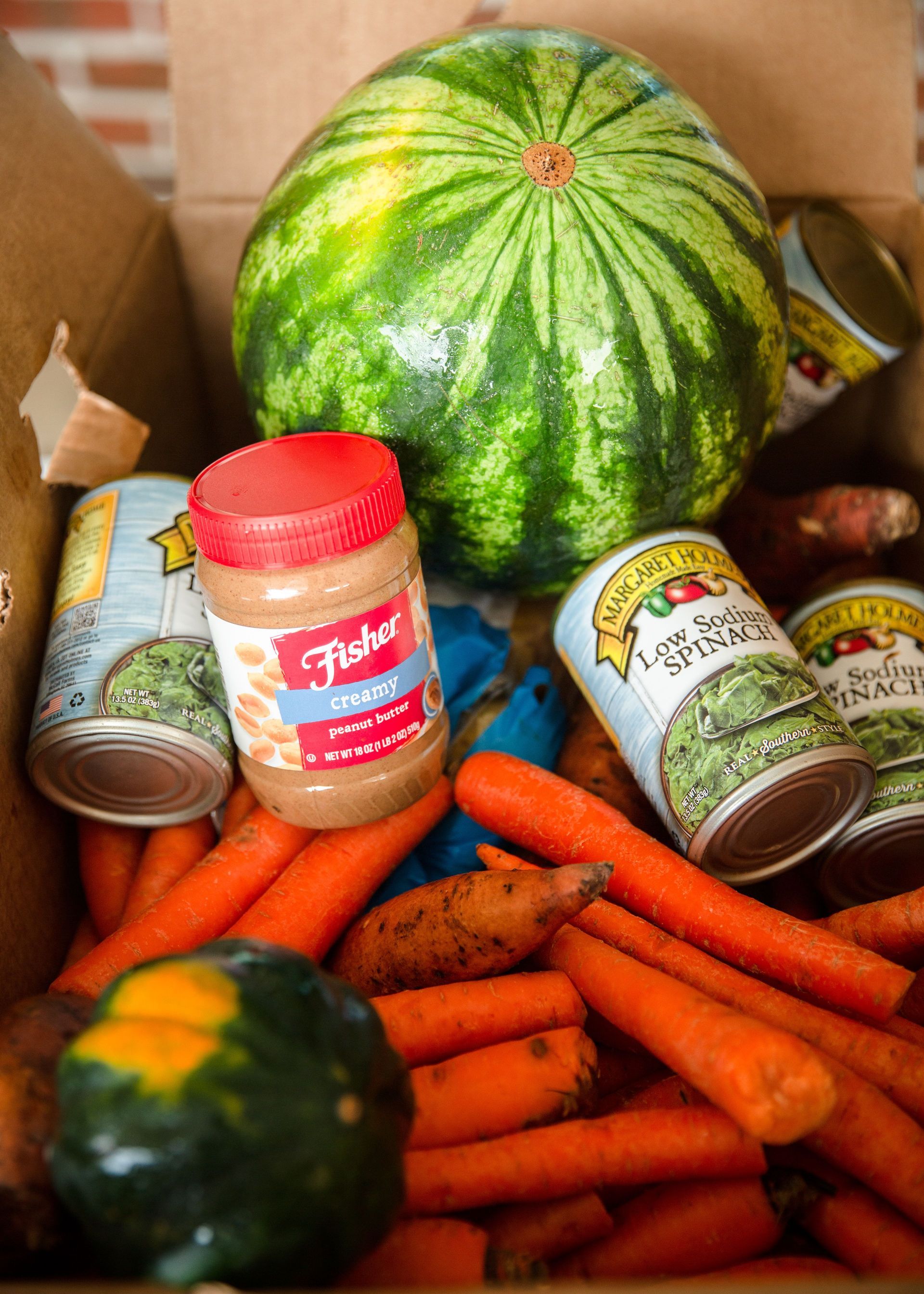 A box filled with carrots peanut butter and watermelon