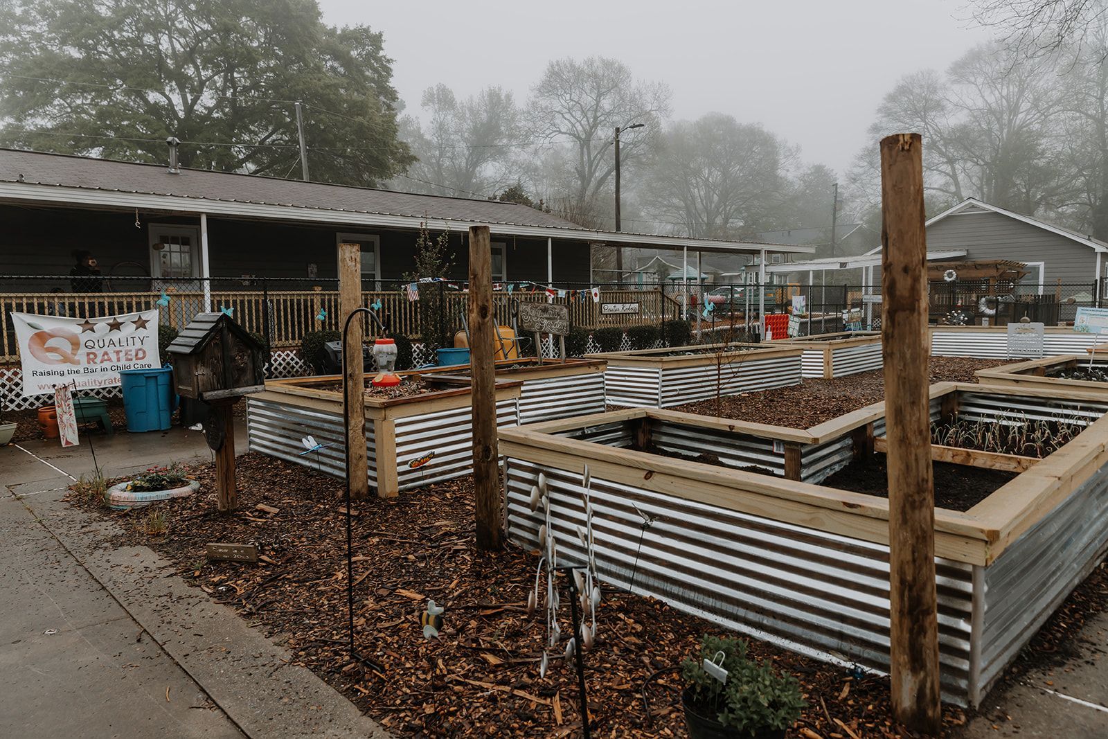 A garden is being built in front of a building on a foggy day.