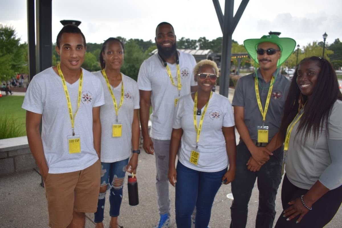 A group of people standing next to each other wearing lanyards.