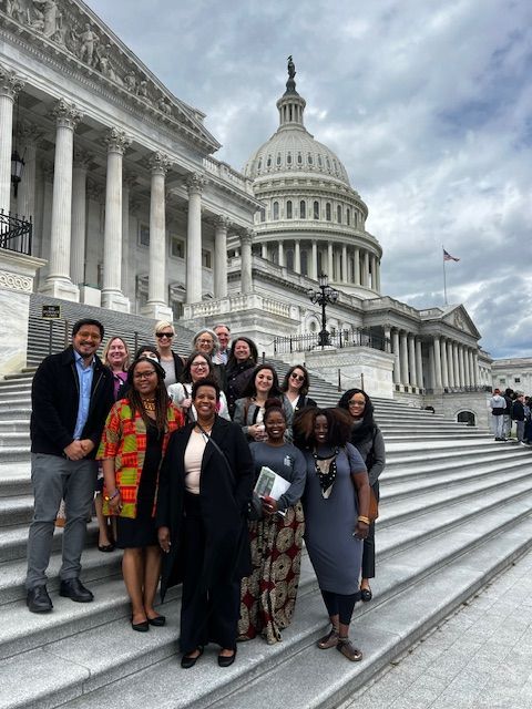 A group of people are standing on the steps of the capitol building.
