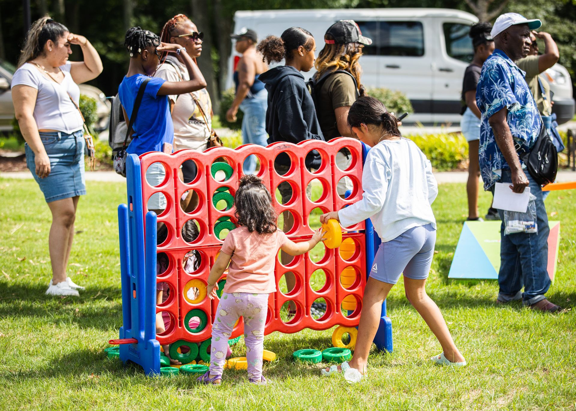 A group of people are playing a game of connect four in a park.
