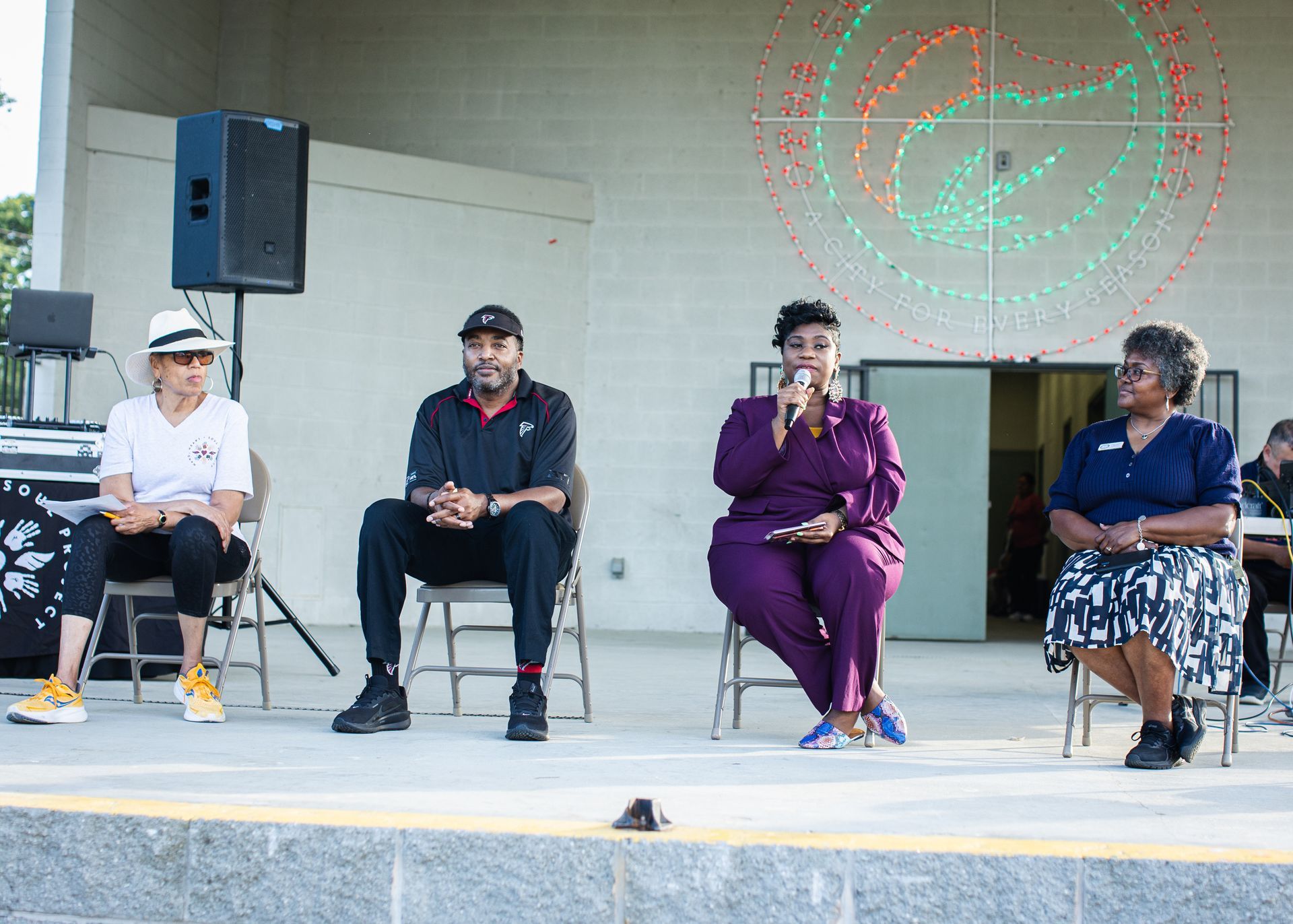 A group of people are sitting in chairs on a stage.