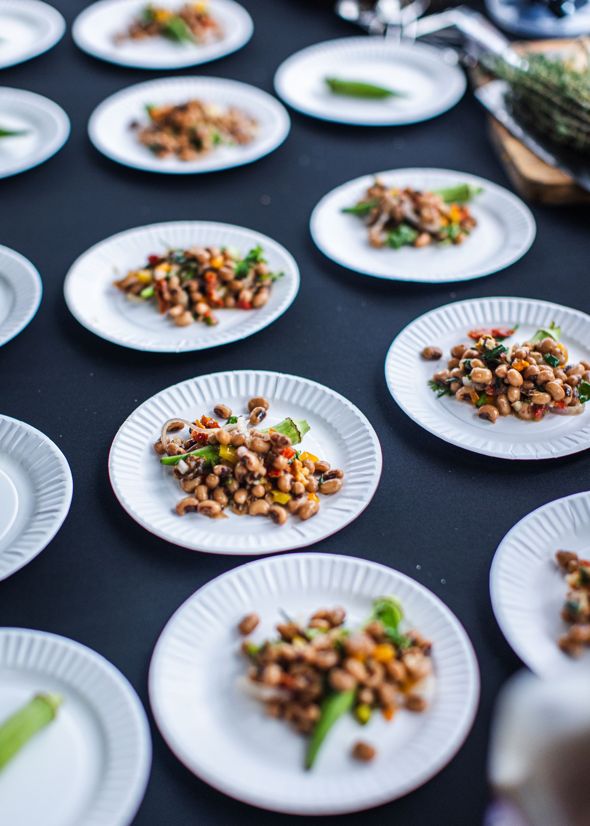 A table topped with paper plates filled with different types of food.