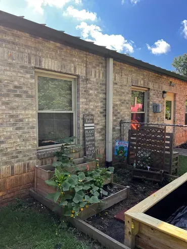 A brick house with a garden in front of it.