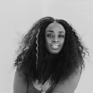 A black and white photo of a woman with long curly hair.