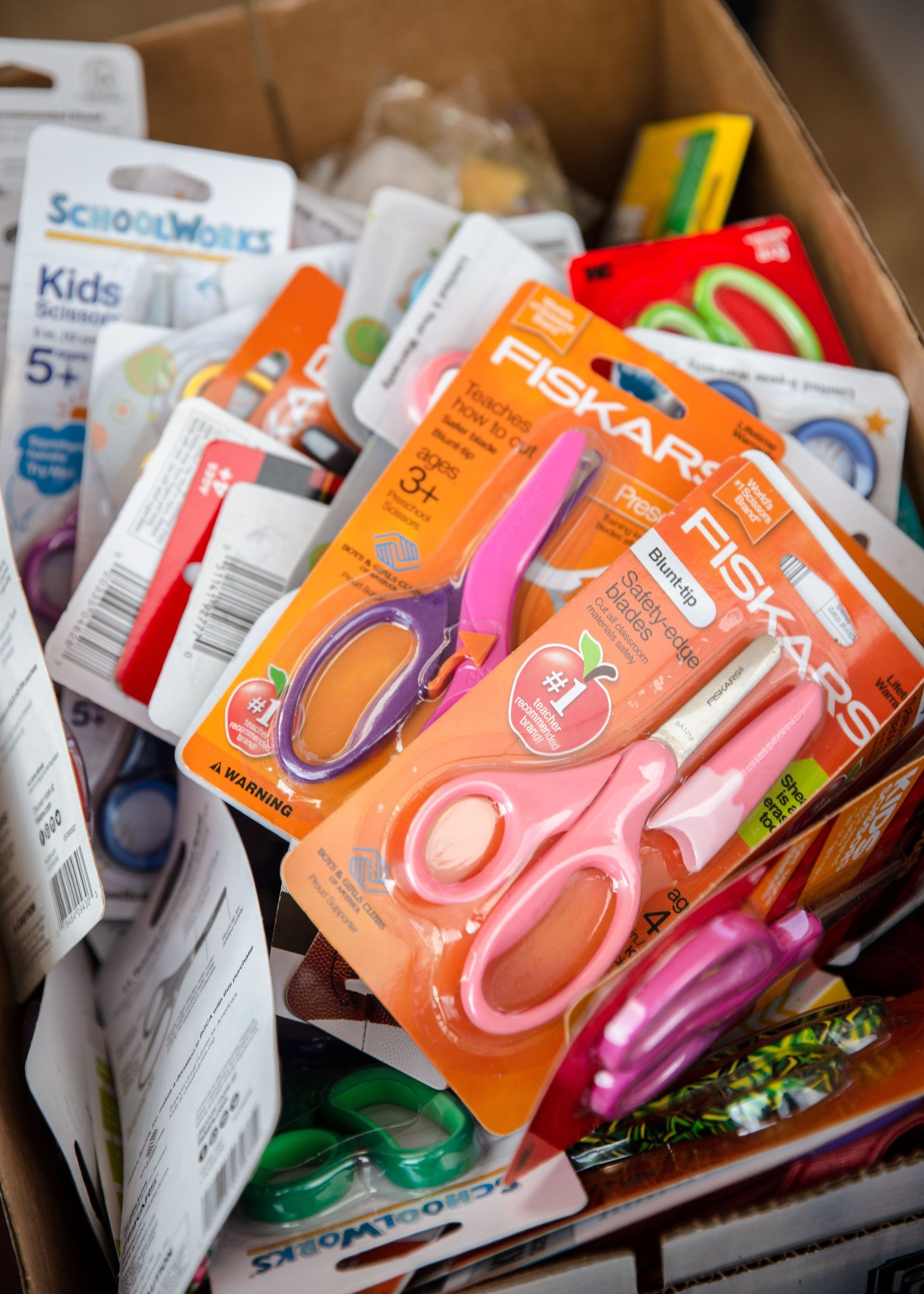 A box filled with scissors and other school supplies