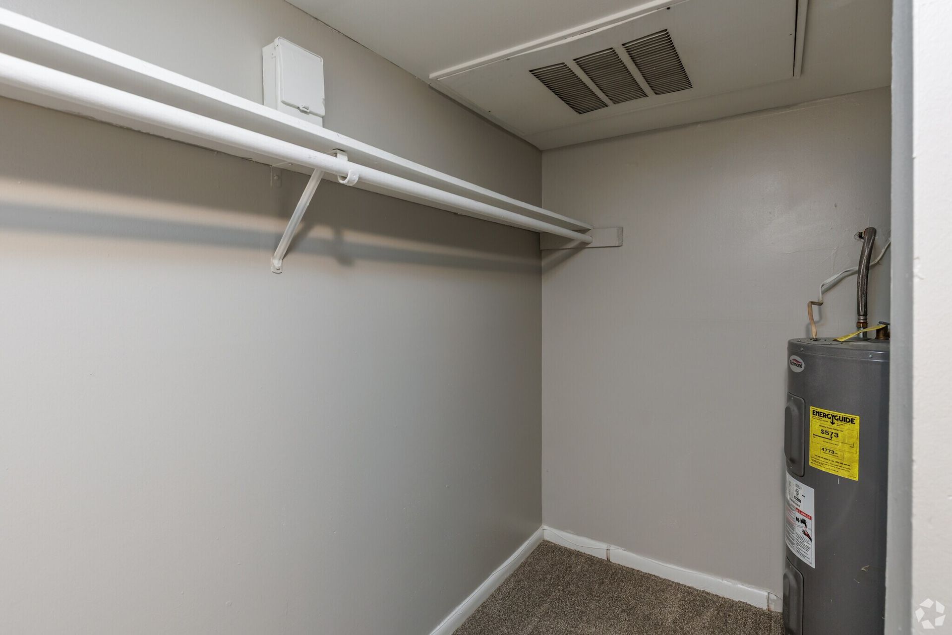 Utility closet with a water heater, white pipes, and shelving. Contact our leasing team at Harborstone Apartments today to schedule a tour of our studio, one-, and two-bedroom apartments in Newport News, VA. 