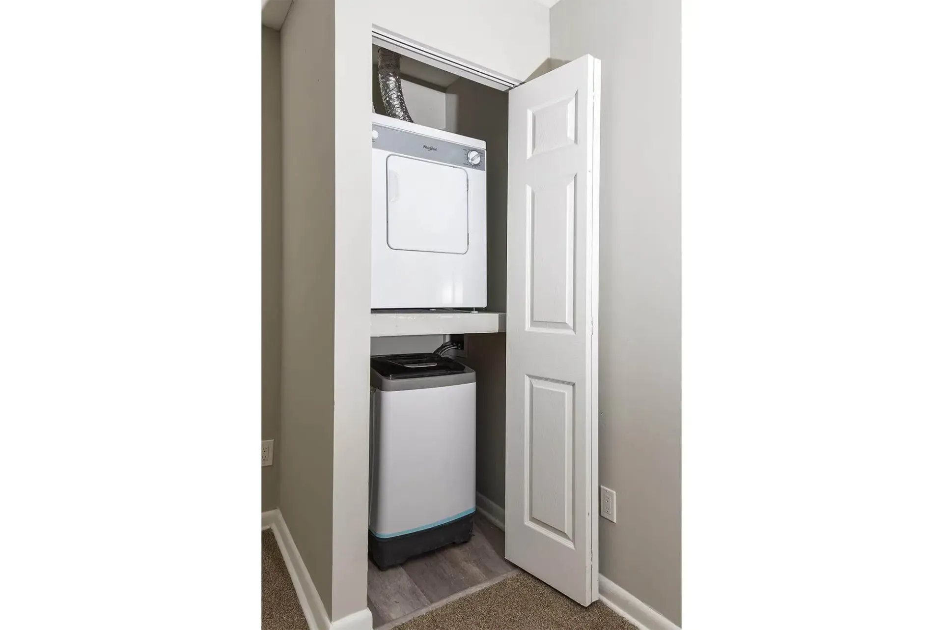 Stacked washer and dryer in a small closet with the door open. Contact our leasing team at Harborstone Apartments today to schedule a tour of our studio, one-, and two-bedroom apartments in Newport News, VA. 