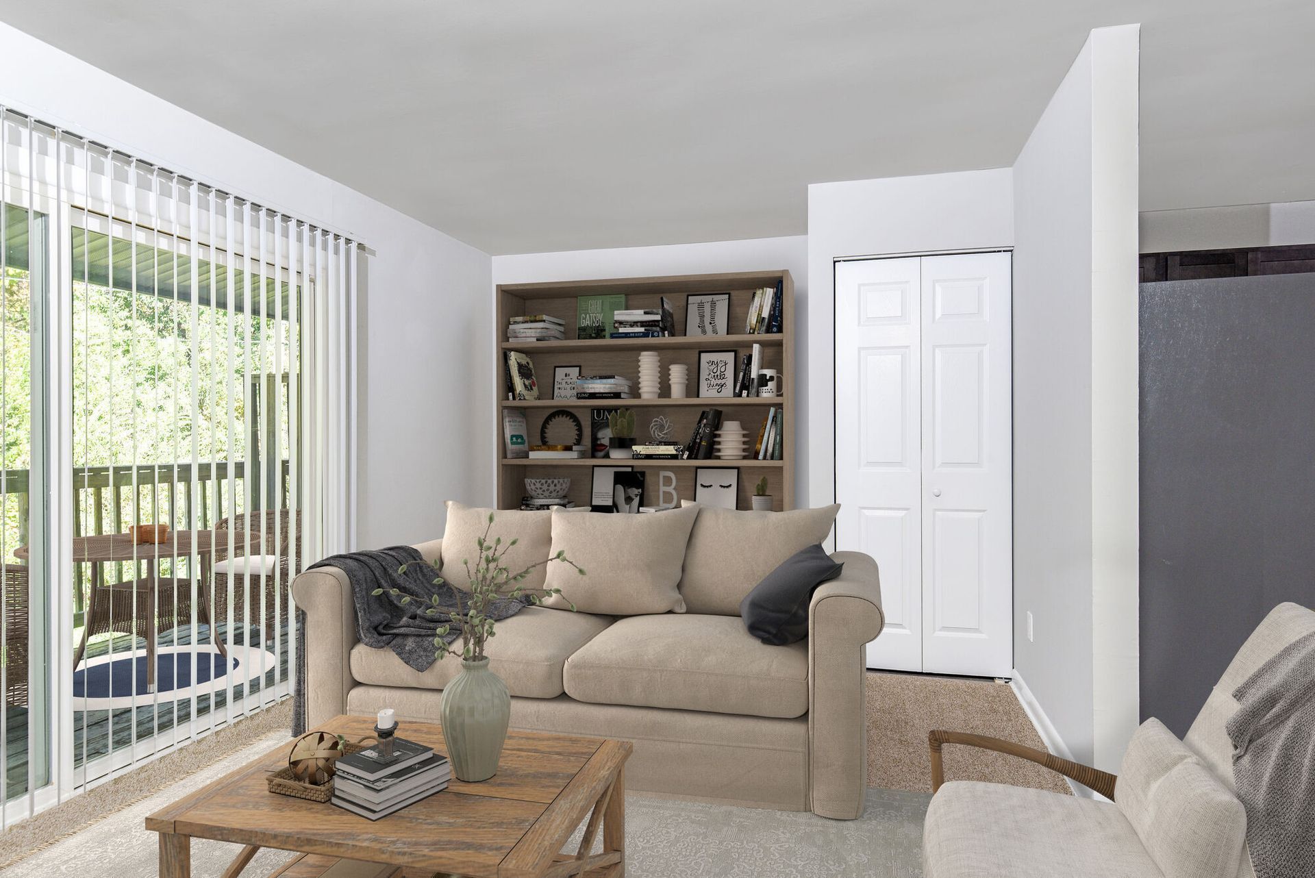 Living room in an apartment with a beige sofa, wooden coffee table, and a tall bookshelf beside a sliding glass door. Contact our leasing team at Harborstone Apartments today to schedule a tour of our studio, one-, and two-bedroom apartments in Newport News, VA. 