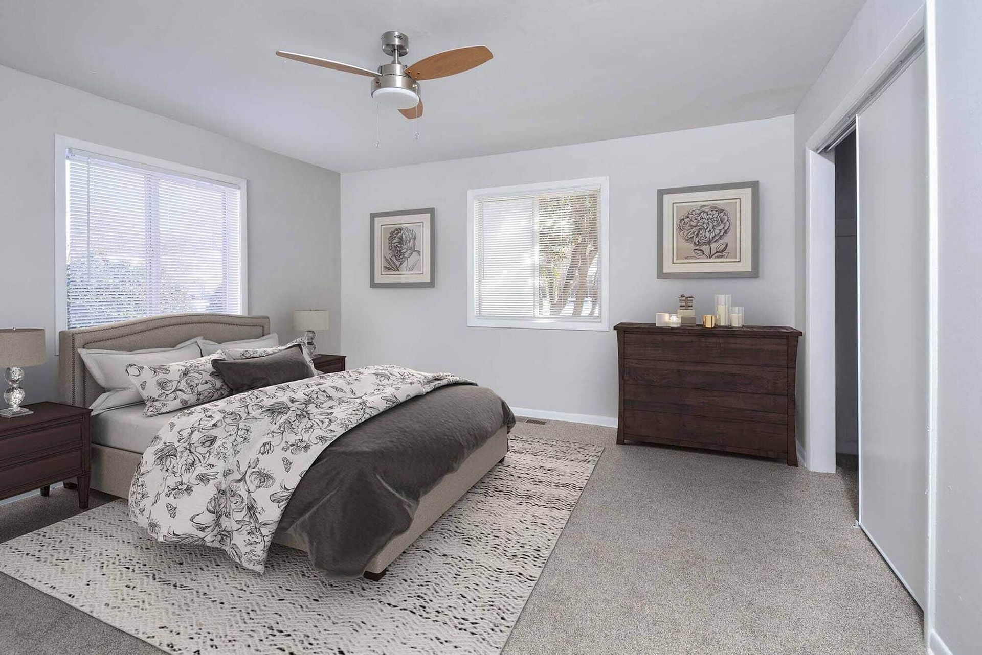 Furnished bedroom in an apartment with a bed, two nightstands, dresser, and ceiling fan. Contact our leasing team at Harborstone Apartments today to schedule a tour of our studio, one-, and two-bedroom apartments in Newport News, VA. 